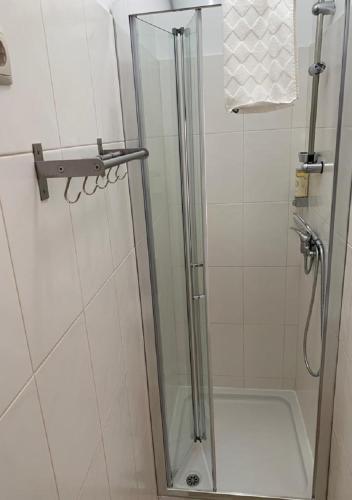 a shower with a glass door in a bathroom at GuimaraesLiving - Hostel & Adventure in Guimarães