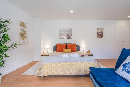 um quarto com uma cama e um sofá azul em Comfy Sunny Flat - Prime Location em Porto