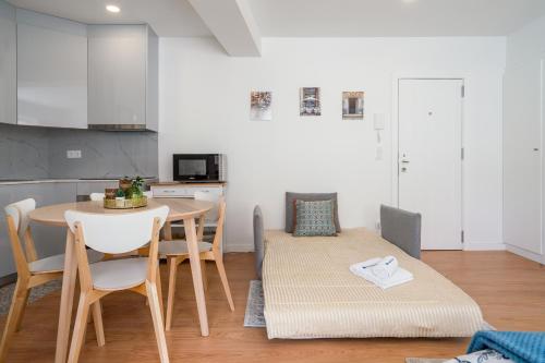uma cozinha e sala de jantar com mesa e cadeiras em Comfy Sunny Flat - Prime Location em Porto