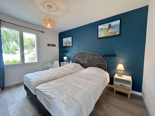 ein Schlafzimmer mit einem großen Bett und einer blauen Wand in der Unterkunft Maison Saint-Pierre-d'Oléron, 4 pièces, 6 personnes - FR-1-246A-195 in Saint-Pierre-dʼOléron