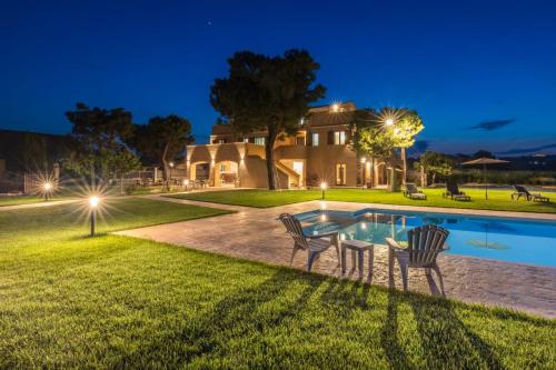 a house with a pool and two chairs in the yard at Casale Ferrantino in Giulianova
