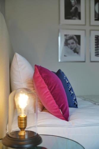 a bed with pillows and a lamp on a table at VILA VITA Rosenpark in Marburg an der Lahn