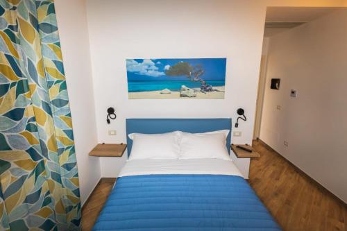 a bedroom with a blue bed and a painting on the wall at Casale Ferrantino in Giulianova