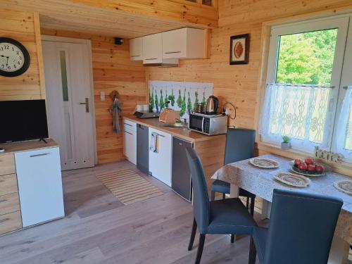 cocina y comedor con mesa en una cabaña en Domki Na Wzgórzu - domek nr 2, en Mrągowo