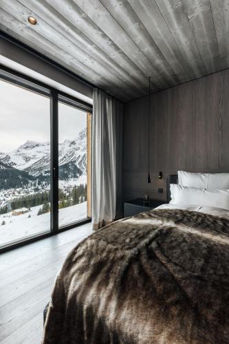 a bedroom with a large bed and a large window at LE CHALET - Luxury Hideaway in Oberlech