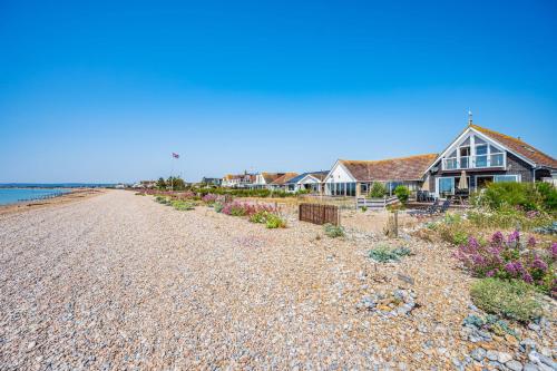 a row of houses on a rocky beach at Pebble Paradise Beachfront Family Getaway in Pevensey