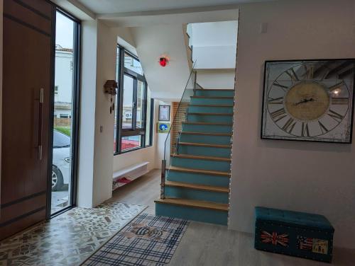 a staircase with a clock on the wall and a clock at Agape Homestay in Magong
