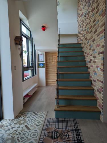 a staircase in a room with a brick wall at Agape Homestay in Magong