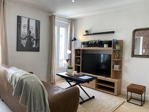 een woonkamer met een bank en een flatscreen-tv bij Le Paris Appart' T2 au centre du Mans in Le Mans