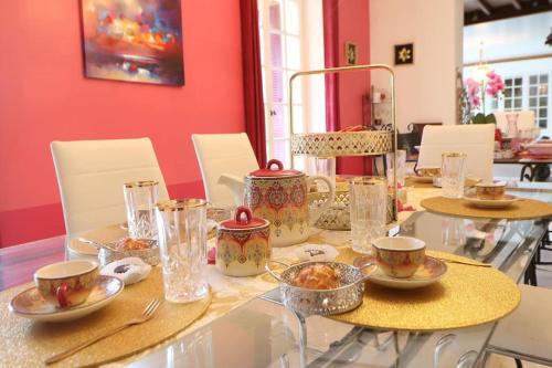 - une table à manger avec des assiettes et des bols de nourriture dans l'établissement L'Alhambra - Gîte Haut de Gamme, à Vierzon