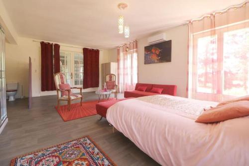een slaapkamer met een bed en een woonkamer bij L'Alhambra - Gîte Haut de Gamme in Vierzon