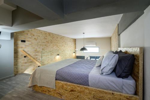 a bedroom with a bed and a brick wall at Loft 2 in Kos Town