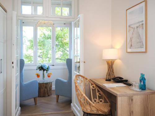 ein Heimbüro mit einem Schreibtisch aus Holz und blauen Stühlen in der Unterkunft Strandvillen Heringsdorf in Heringsdorf
