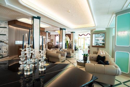 una hall con divani e tavolo con bicchieri di Hotel Carlton a Lido di Jesolo