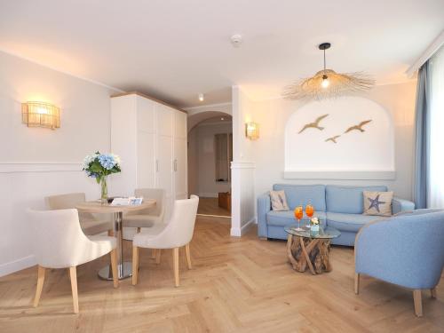 a living room with a blue couch and a table at Strandvillen Heringsdorf in Heringsdorf