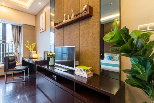 an office with a desk with a tv and a chair at Livetour Hotel Kehui Golden Valley Guanzhou in Guangzhou