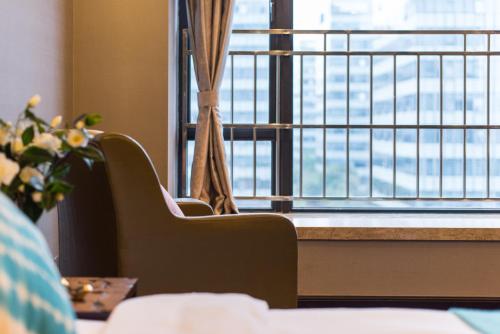 a room with a large window with chairs and a table at Livetour Hotel Kehui Golden Valley Guanzhou in Guangzhou