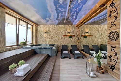 ビャウカにあるAparthotel Góralski Spaの天井のある客室で、テーブルと椅子が備わります。