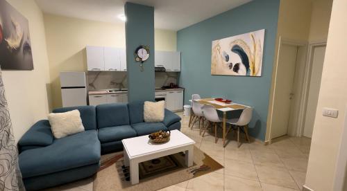 a living room with a blue couch and a table at Villa Apartments S&F City Centre in Tirana