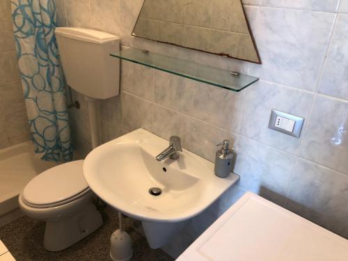 a bathroom with a sink and a toilet and a mirror at Casa vacanze Riomaggiore in Riomaggiore