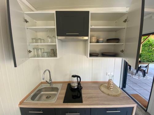 a small kitchen with a sink and a stove at Tiny House QiriH in Zierikzee