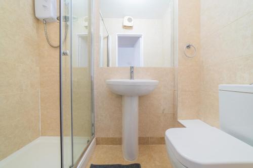 ein Bad mit einem WC, einem Waschbecken und einer Dusche in der Unterkunft 7 Devon Court, Freshwater East, Pemborke in Hodgeston