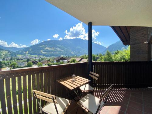 a table and chairs on a balcony with mountains at AlpenApart Montafon - Haus Engstler in Schruns-Tschagguns