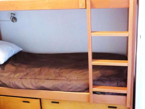 - un lit superposé avec une étagère en bois à côté d'un lit dans l'établissement Studio alcôve avec piscine et parking, à 300m de la plage, pour 4 personnes - FR-1-607-139, au Cap d'Agde