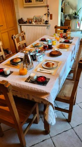 a long table with plates of food on it at Chambre D'hôtes Villa de la Sueur au Bonheur in La Bouilladisse