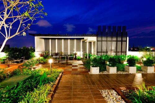 a garden at night with a building at Royal Princess Larn Luang - SHA Extra Plus in Bangkok
