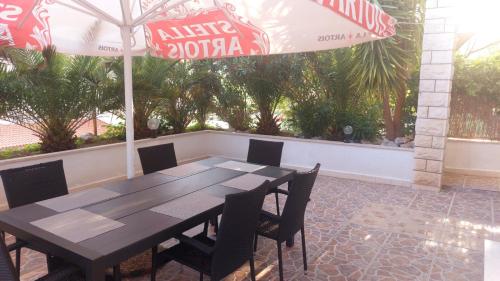 un tavolo con sedie e un ombrellone su un patio di Apartments Duce (122) a Duće