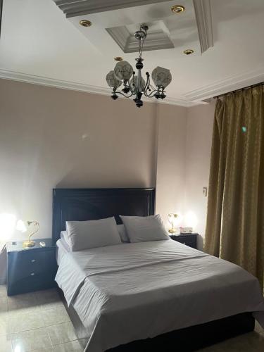 カイロにあるRehab City VIP Full Serviced Apartment الرحاب Guest satisfaction guaranteedのベッドルーム1室(大型ベッド1台、シャンデリア付)