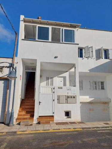 a white house with a gate and a garage at Dunas de Famara in Famara
