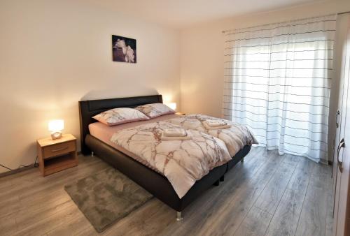 a bedroom with a large bed and a window at Apartman Badi in Dugopolje
