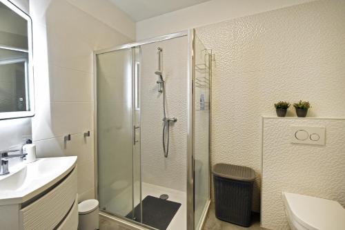 a bathroom with a shower and a toilet and a sink at Apartman Badi in Dugopolje