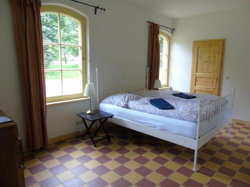 een slaapkamer met een bed en een tegelvloer bij Schmiede der Wasserburg Liepen in Gielow