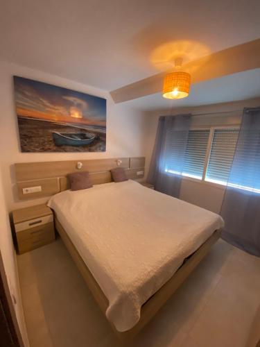 a bedroom with a bed and a painting on the wall at Apartamento Calpe in Calpe