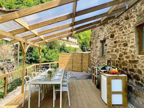 a patio with a table and chairs under a wooden pergola at Casa Pirri in Espinama