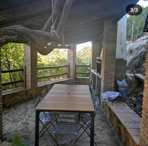 una mesa de madera y sillas en un patio en Casa Rural El Gandulillo en Castril