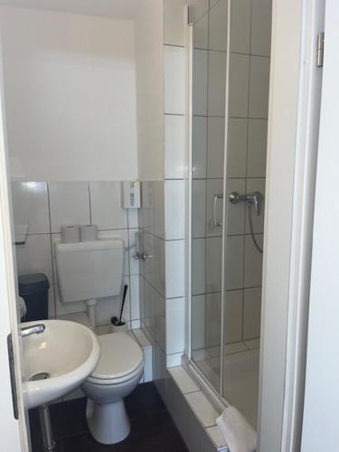La salle de bains est pourvue de toilettes, d'une douche et d'un lavabo. dans l'établissement Hotel Lübecker Hof, à Lunebourg