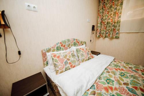 um quarto com uma cama e um telefone na parede em TwinHouse Karakol em Karakol