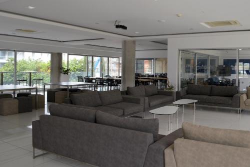 una sala de estar con sofás, mesas y ventanas en UC Hall Residence en Nicosia