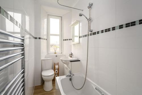 bagno bianco con servizi igienici e lavandino di 2BR New Town Castle View Apartment a Edimburgo
