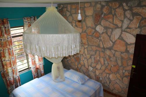 a lamp in a room with a stone wall at Henotes B&B in Kamuli