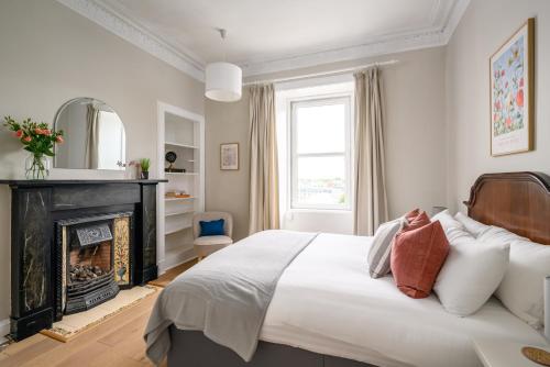 una camera con un grande letto e un camino di 2BR New Town Castle View Apartment a Edimburgo