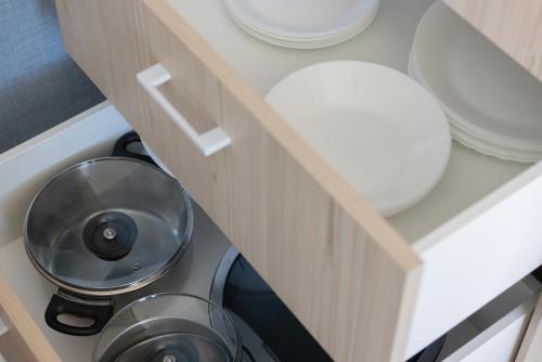 a cabinet with a bowl and plates in it at BURSZTYN - BERNSTEIN APARTMENTS in Dąbki