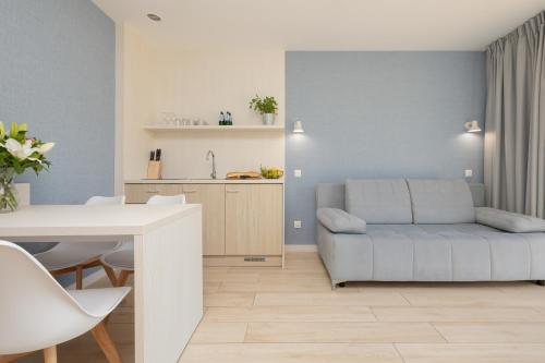 a kitchen and living room with a couch and a table at BURSZTYN - BERNSTEIN APARTMENTS in Dąbki
