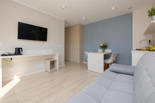 ein Wohnzimmer mit einem weißen Sofa und einem Tisch in der Unterkunft BURSZTYN - BERNSTEIN APARTMENTS in Dąbki