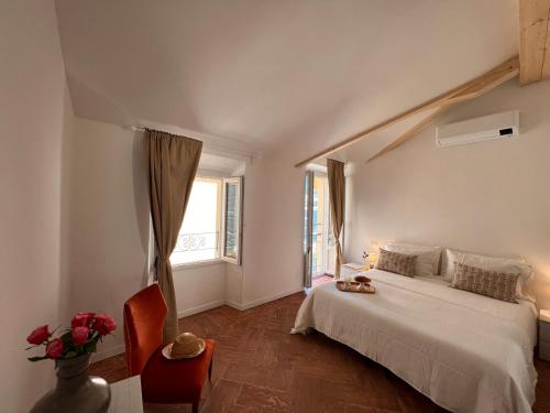 1 dormitorio con cama blanca y ventana en La Finestra sul Molo - by MyHomeInComo, en Torno