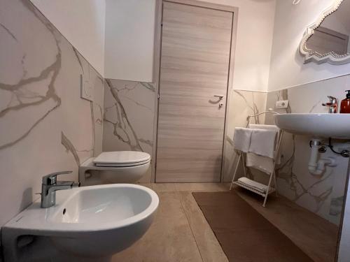Baño blanco con lavabo y aseo en La Finestra sul Molo - by MyHomeInComo, en Torno